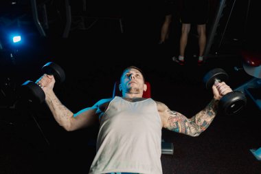 Yakışıklı atletik spor salonunda yalan sırasında halter ıslahı tarafından göğüs kasları trenler.