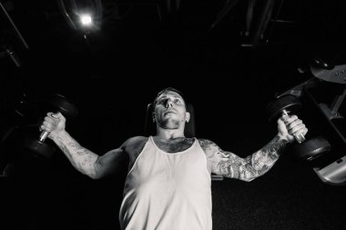 Yakışıklı atletik spor salonunda yalan sırasında halter ıslahı tarafından göğüs kasları trenler.