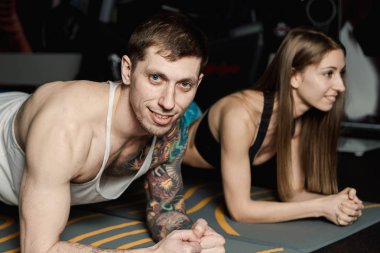 sportif erkek ve kadının tahta çekirdek geri egzersiz eğitim yapması uygun ve kas kavramı spor salonu spor sporcu fitness egzersiz güç güç düğmesine basın.