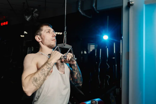 Przystojny mężczyzna sportowiec, poćwiczyć na siłowni maszyny w siłowni. — Zdjęcie stockowe