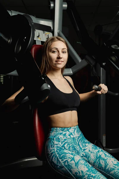 Активная красивая модель фитнеса тренирует грудные мышцы на тренажере в тренажерном зале . — стоковое фото