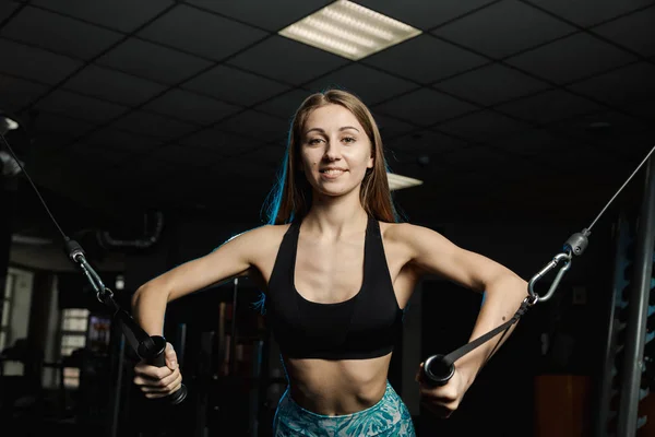 Активная красивая модель фитнеса тренирует грудные мышцы на тренажере в тренажерном зале . — стоковое фото