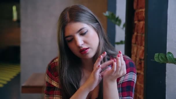 Una hermosa mujer de negocios está sentada en una mesa con un portátil en un café y trabajando . — Vídeo de stock