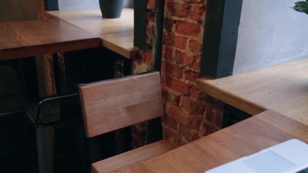 Local de trabalho em um café pela janela com um laptop na mesa . — Vídeo de Stock