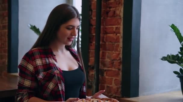 Schöne Geschäftsfrau legt eine Pizza auf den Tisch, die aber einen Laptop kostet. — Stockvideo
