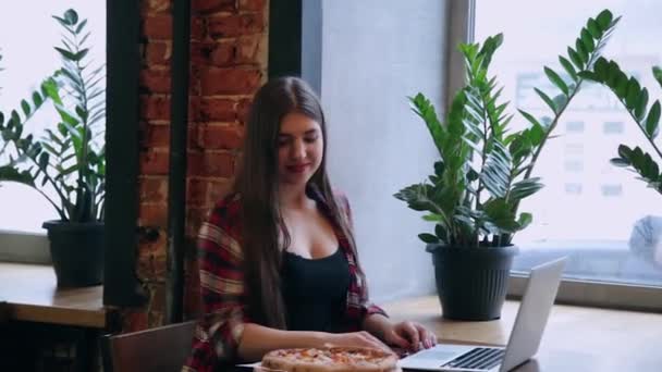 Hermosa mujer va a comer pizza en un café . — Vídeos de Stock