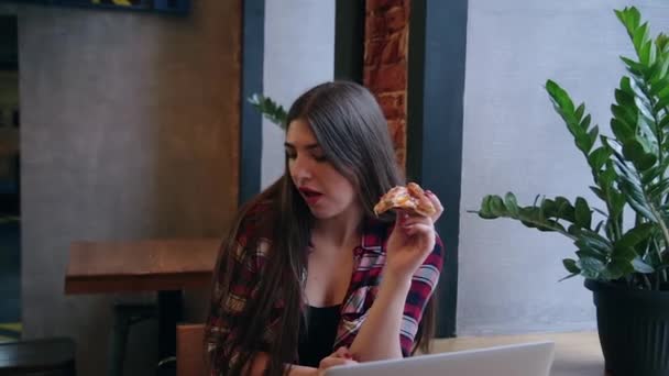 Mulher bonita atraente comer pizza em um café . — Vídeo de Stock