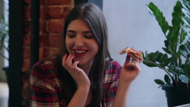 Schöne attraktive Frau isst Pizza in einem Café. — Stockvideo
