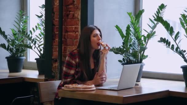 Hermosa mujer atractiva comiendo pizza en un café . — Vídeos de Stock