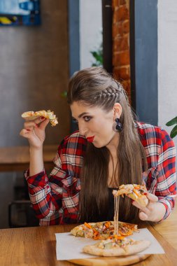 Bir kafede cam kenarında oturan ve pizza yemek güzel ve seksi kız.