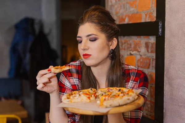 カフェの窓辺に座っていると、ピザを食べて美しく、セクシーな女の子. — ストック写真