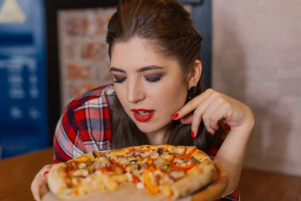 カフェの窓辺に座っていると、ピザを食べて美しく、セクシーな女の子. — ストック写真