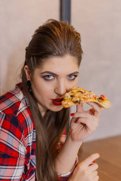 Piękna i seksowna dziewczyna siedzi przy stole z pizzy w kawiarni. — Zdjęcie stockowe