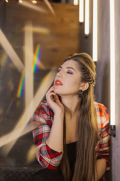 Menina bonita e sexy posando para um fotógrafo nas escadas de ferro preto com lâmpadas em um café . — Fotografia de Stock