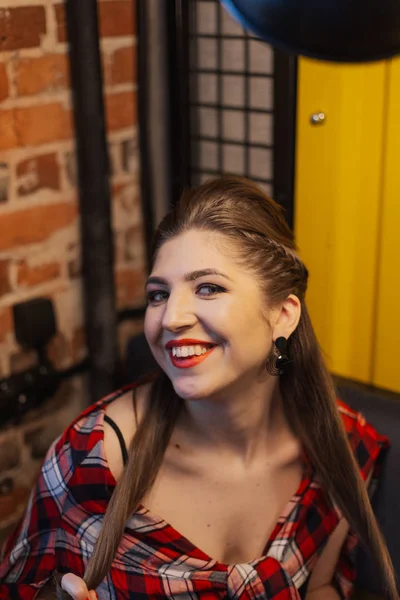 Hermosa y sexy chica sentada junto a la ventana en un café y sonriendo . — Foto de Stock