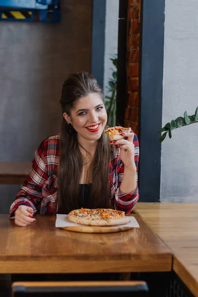 Красива і сексуальна дівчина сидить за столом з піцою в кафе . — стокове фото