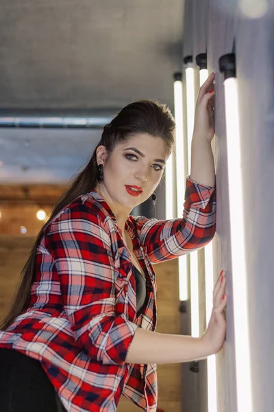Schöne und sexy Mädchen posiert für einen Fotografen auf der schwarzen Eisentreppe mit Lampen in einem Café. — Stockfoto