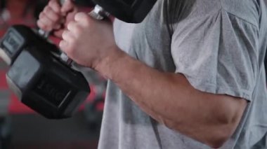 Dumbbell pazı salonunda eğitim yakışıklı atletik erkek.