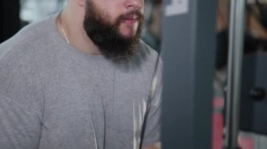 Triceps blok simülatör spor salonunda yakışıklı atletik erkek trenler.