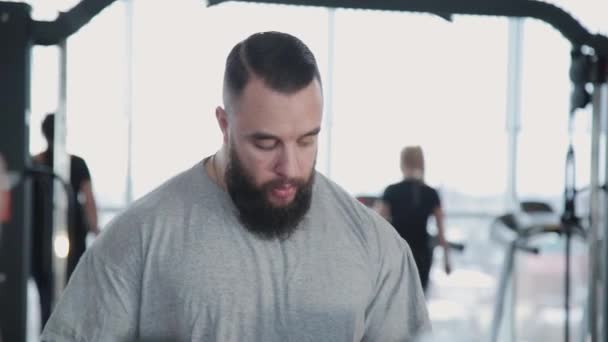 Guapo atlético hombre entrenamiento dumbbell bíceps en el gimnasio . — Vídeos de Stock