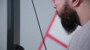 Triceps blok simülatör spor salonunda yakışıklı atletik erkek trenler.