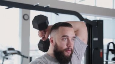 Triceps blok simülatör spor salonunda yakışıklı atletik erkek trenler.