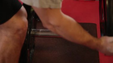 Yakışıklı atletik bir halter salonunda ağırlık koyar.