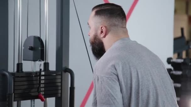 Bonito atlético treina tríceps no simulador de blocos no ginásio . — Vídeo de Stock