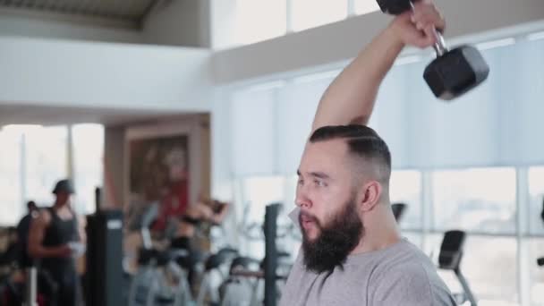 Atletický muž vlaky triceps na simulátoru blok v tělocvičně. — Stock video