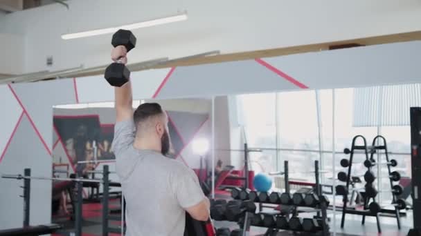 Hombre atlético guapo entrena tríceps en el simulador de bloque en el gimnasio . — Vídeos de Stock