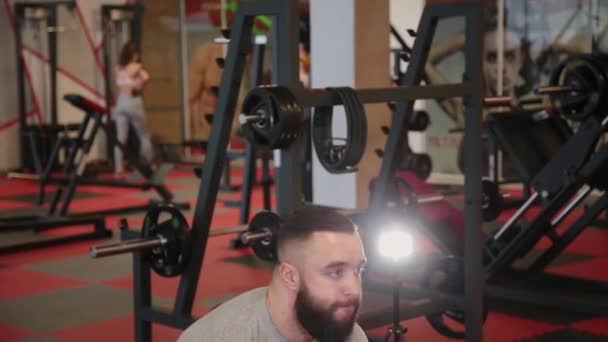 Hombre atlético guapo realiza deadlift en el gimnasio — Vídeo de stock