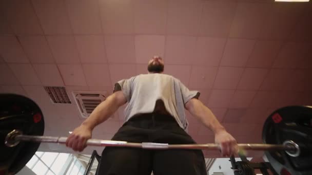 Knappe atletische man voert deadlift in de sportschool — Stockvideo