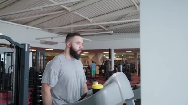 Hombre atlético guapo haciendo ejercicio en la cinta de correr en el gimnasio . — Vídeos de Stock