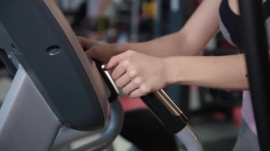 Eliptik bir eğitmen salonunda güzel atletik genç kız trende.