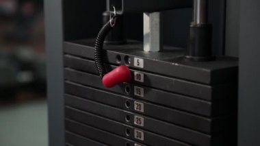 Simülatör ağırlığıyla bar değiştirmek bir kızın yakın çekim. Vücut geliştirme. Simülatör üzerinde ağırlığı spor salonunda, ayarlar için kız gider.