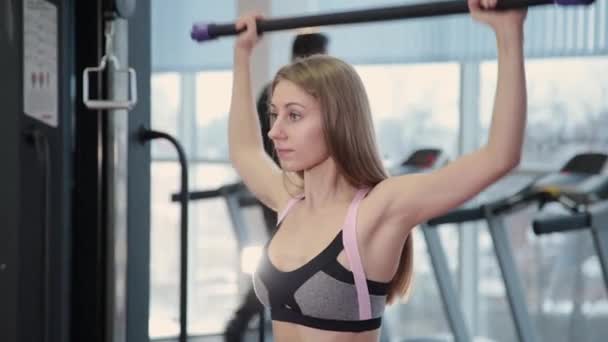 Όμορφη αθλητική νεαρή κοπέλα ασκήσεις με γυμναστικές ραβδί στο γυμναστήριο. — Αρχείο Βίντεο
