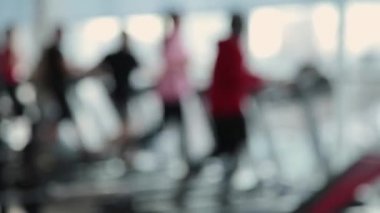 Bulanık kadın spor salonunda bir koşu bandı üzerinde çalışan.