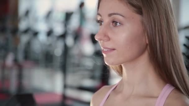 Hermosa atlética joven entrena pesas bíceps en el gimnasio . — Vídeos de Stock