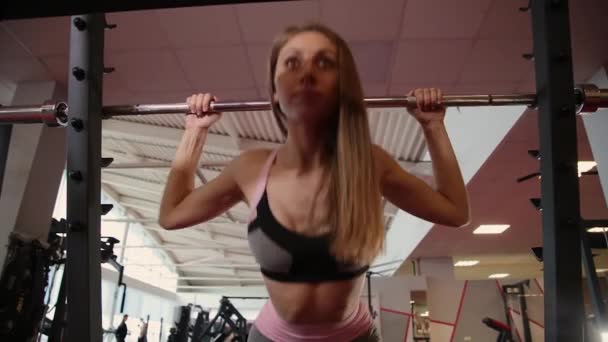 Hermosa chica atlética que viene al bar para sentadillas en el gimnasio . — Vídeos de Stock