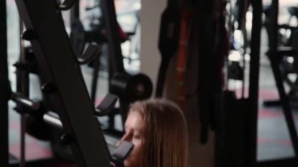Hermosa chica atlética se agacha en los hombros en el gimnasio . — Vídeos de Stock