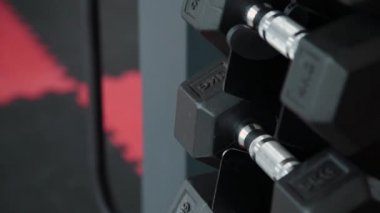 Spor salonunda dumbbells ile stand.