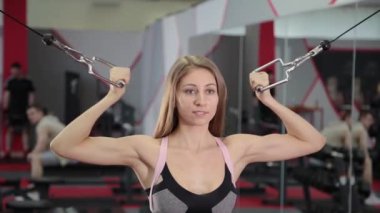 Pazı bir blok simülatörü simülatör spor salonunda güzel atletik genç kız trenler.