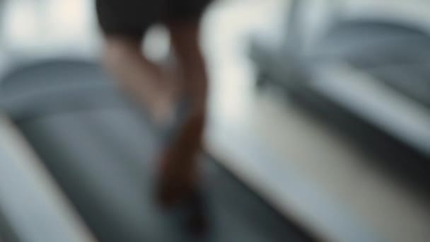 Размытая женщина бежит на беговой дорожке в спортзале . — стоковое видео