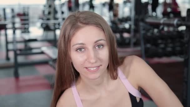 Όμορφη αθλητική νεαρή κοπέλα τρένα αλτήρες δικέφαλου στο γυμναστήριο. — Αρχείο Βίντεο