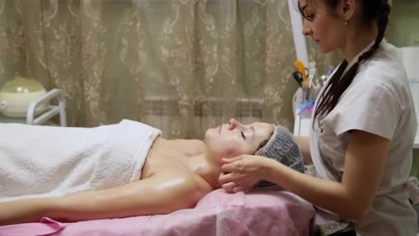 Spa donna massaggio facciale. Massaggio viso nel salone di bellezza termale. Femmina godendo rilassante massaggio viso in cosmetologia centro termale. Cura del corpo, cura della pelle, benessere, trattamento di bellezza . — Video Stock