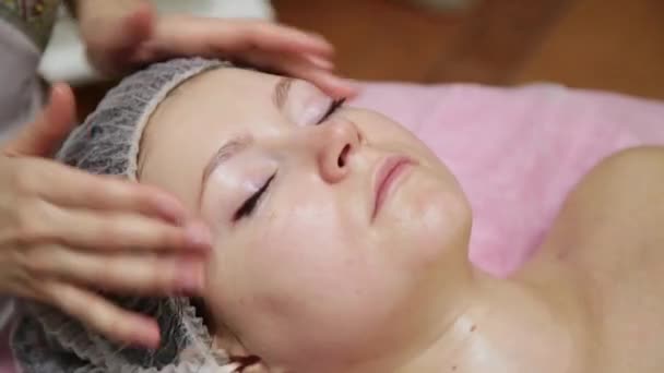 Spa mujer masaje facial. Masaje facial en salón de spa de belleza. Mujer disfrutando de masajes faciales relajantes en el centro de spa de cosmetología. Cuidado corporal, cuidado de la piel, bienestar, tratamiento de belleza . — Vídeo de stock