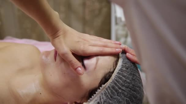 Spa donna massaggio facciale. Massaggio viso nel salone di bellezza termale. Femmina godendo rilassante massaggio viso in cosmetologia centro termale. Cura del corpo, cura della pelle, benessere, trattamento di bellezza . — Video Stock