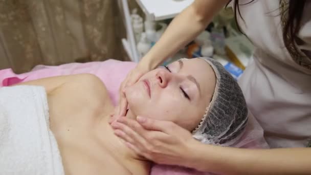 迷人的女性在水疗健康俱乐部得到面部按摩 美容师在豪华美容院做面部 颈部和肩部按摩 Beautyful 年轻女子 — 图库视频影像