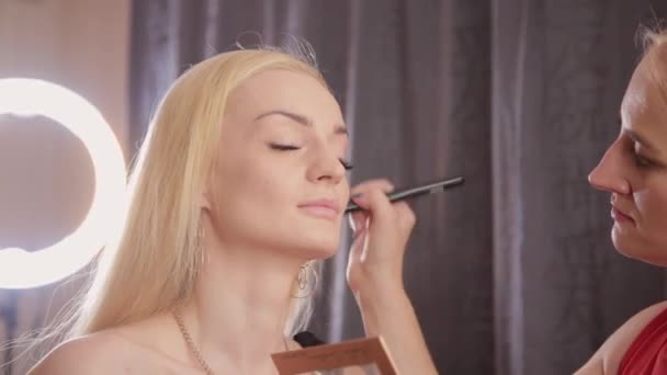 Truccatore fa trucco professionale per bella donna . — Video Stock