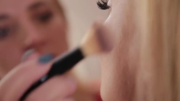 Maquiagem artista faz maquiagem profissional para mulher bonita . — Vídeo de Stock